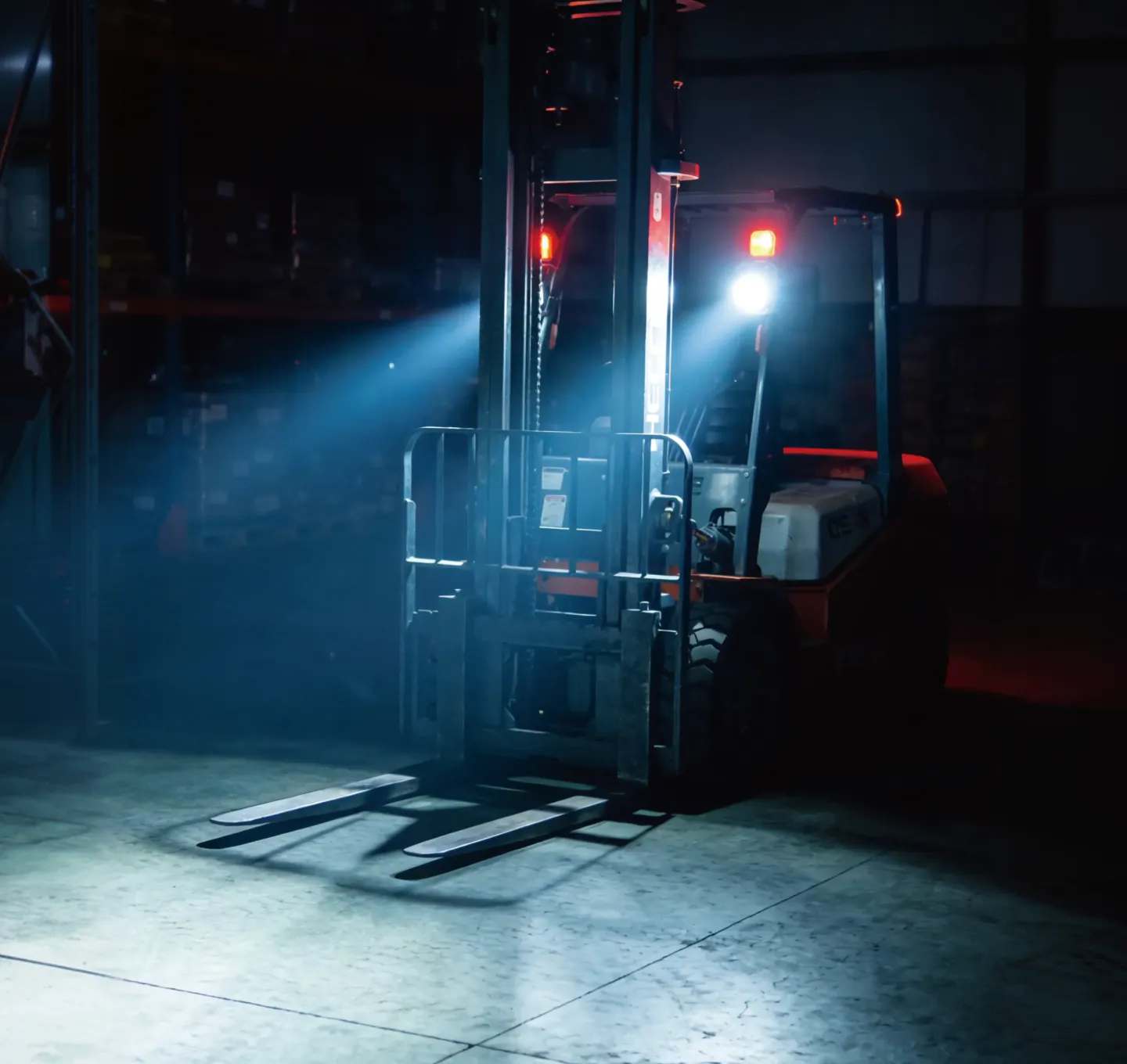 Forklift operating in a warehouse with bright LED work lights